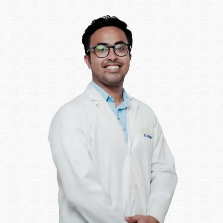 A smiling man wears glasses, a light blue shirt, and a white lab coat, standing confidently against a plain white background.