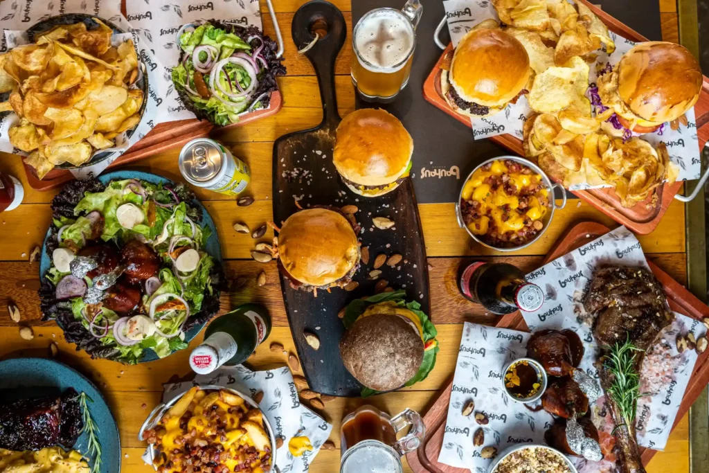 Foods to avoid in piles including burgers, chips, fried foods, and processed meat.
